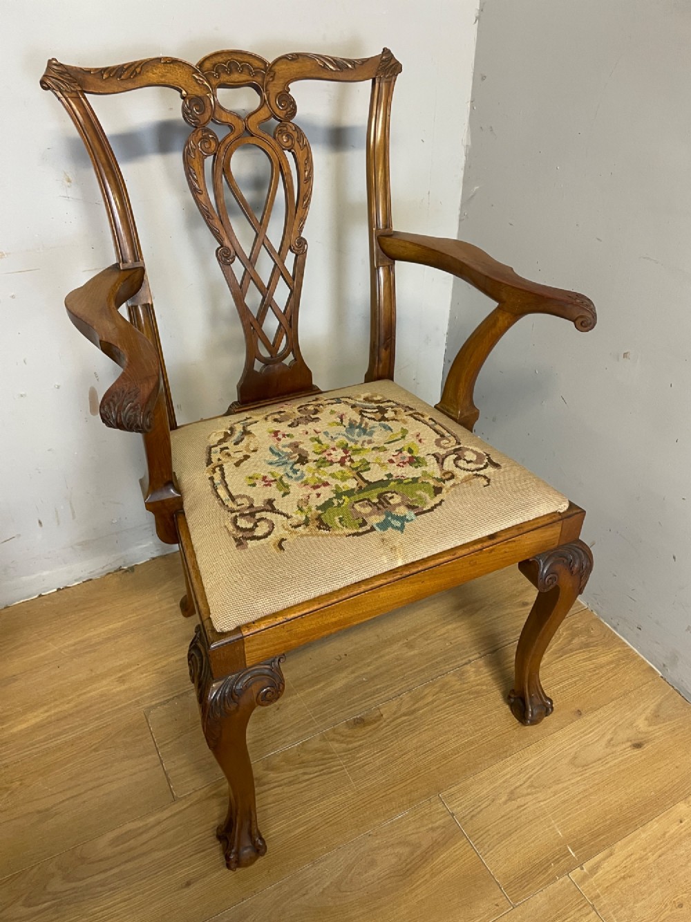 A set of eight dark mahogany Chippendale Revival dining chairs featuring carved pierced back splats, tapestry seat pads, and cabriole legs with ball and claw feet. View V