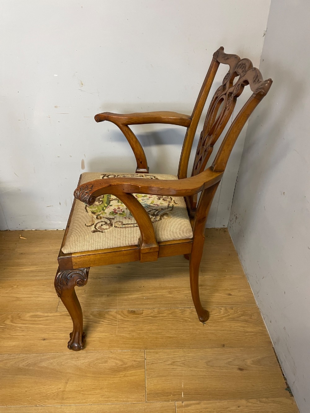 A set of eight dark mahogany Chippendale Revival dining chairs featuring carved pierced back splats, tapestry seat pads, and cabriole legs with ball and claw feet. View VII