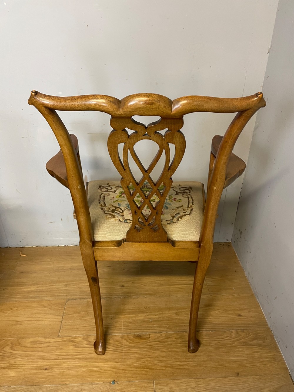 A set of eight dark mahogany Chippendale Revival dining chairs featuring carved pierced back splats, tapestry seat pads, and cabriole legs with ball and claw feet. View VIII
