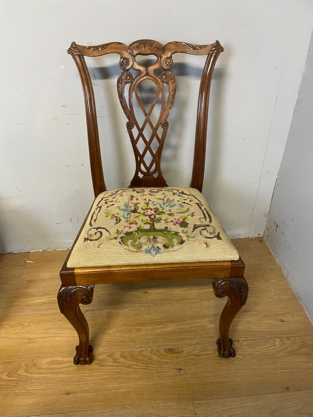 A set of eight dark mahogany Chippendale Revival dining chairs featuring carved pierced back splats, tapestry seat pads, and cabriole legs with ball and claw feet. View IX
