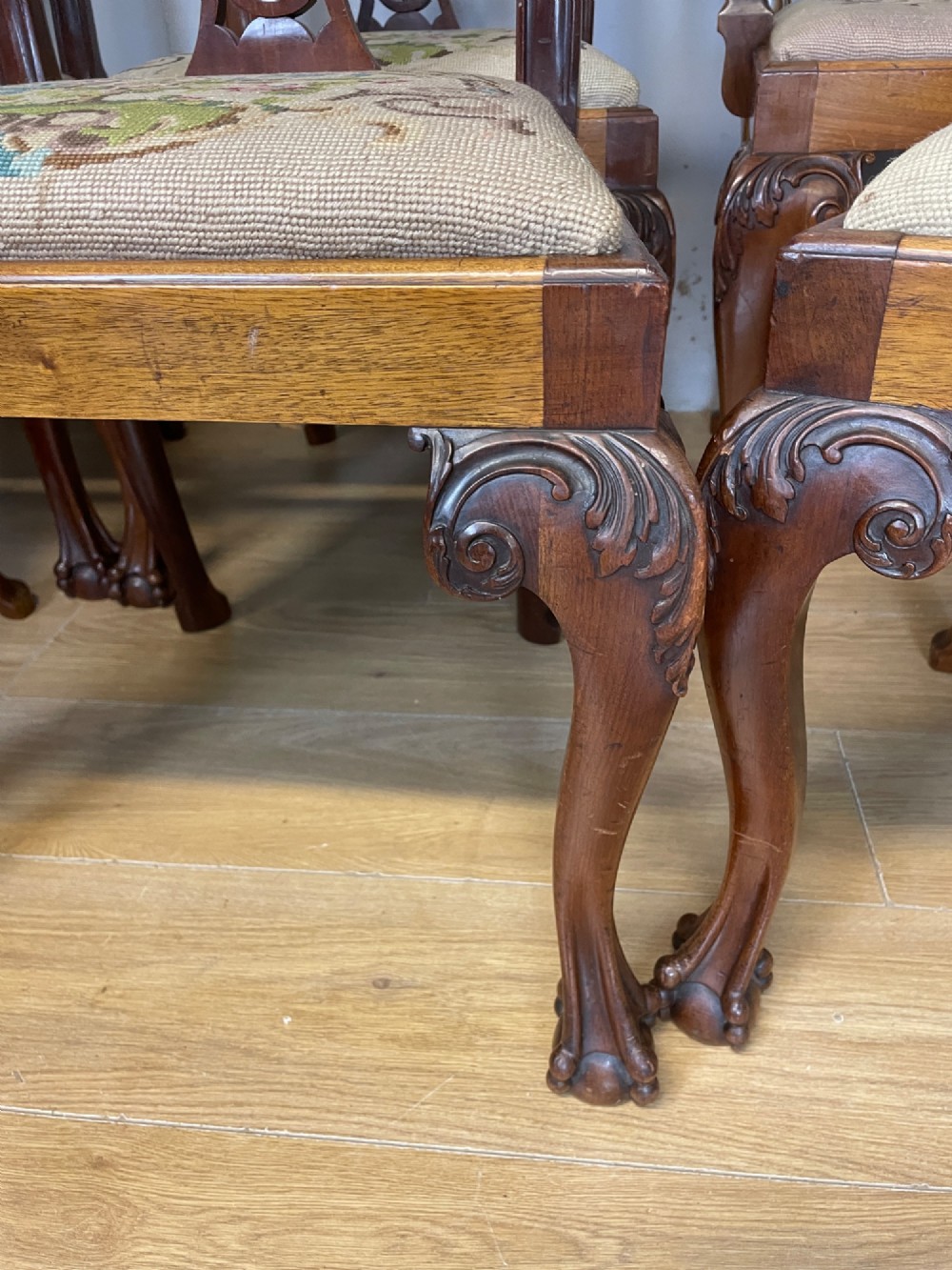 A set of eight dark mahogany Chippendale Revival dining chairs featuring carved pierced back splats, tapestry seat pads, and cabriole legs with ball and claw feet. View XIII