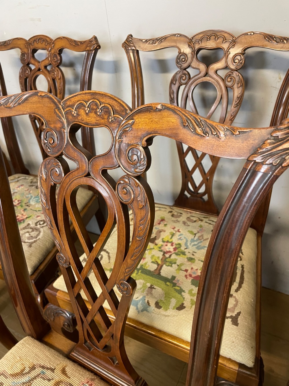 A set of eight dark mahogany Chippendale Revival dining chairs featuring carved pierced back splats, tapestry seat pads, and cabriole legs with ball and claw feet. View XIV