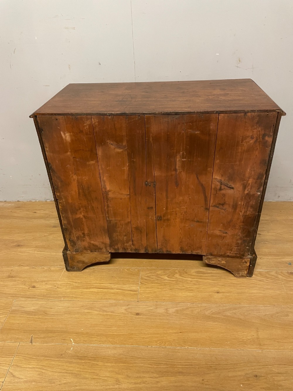 A George III period mahogany chest of drawers featuring four graduated drawers with brass swan-neck handles, diamond keyhole escutcheons, and bracket feet. View VII