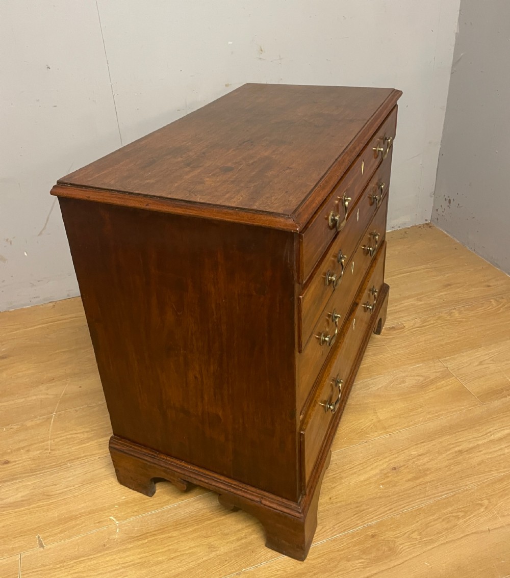 A George III period mahogany chest of drawers featuring four graduated drawers with brass swan-neck handles, diamond keyhole escutcheons, and bracket feet. View VIII