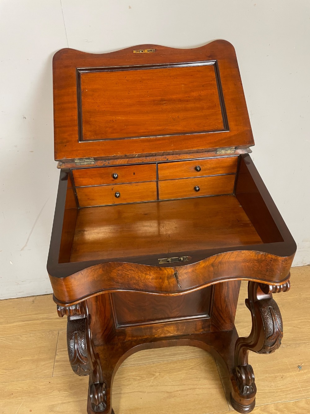 A late 19th-century walnut Davenport desk featuring a sloped leather writing top, carved cabriole front supports, and side drawers. View IV