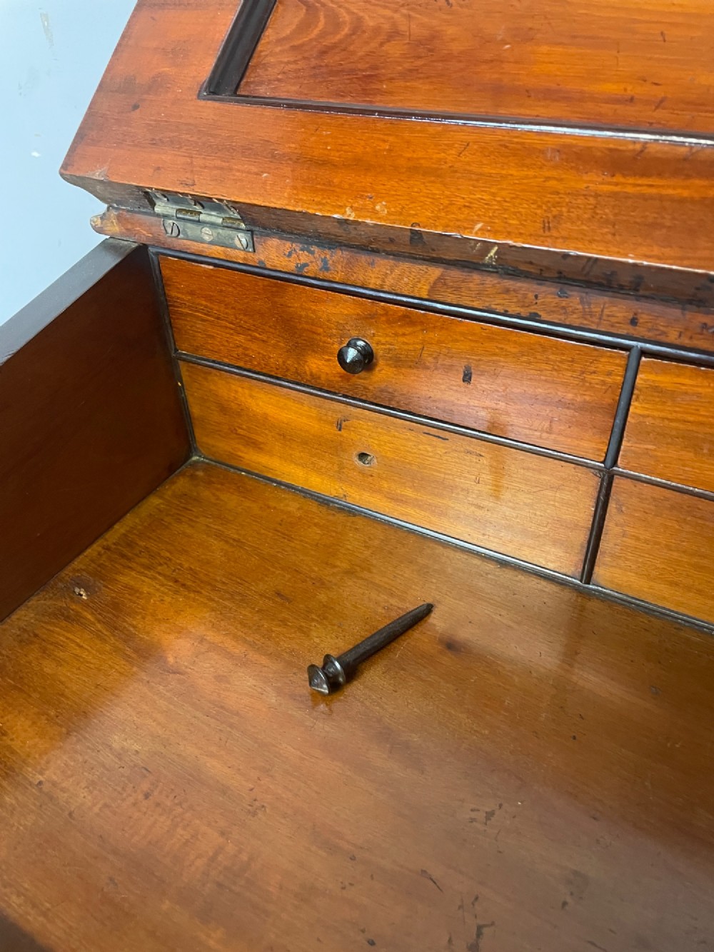 A late 19th-century walnut Davenport desk featuring a sloped leather writing top, carved cabriole front supports, and side drawers. View V