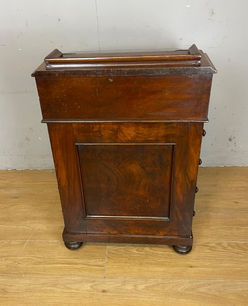 A late 19th-century walnut Davenport desk featuring a sloped leather writing top, carved cabriole front supports, and side drawers. View IX