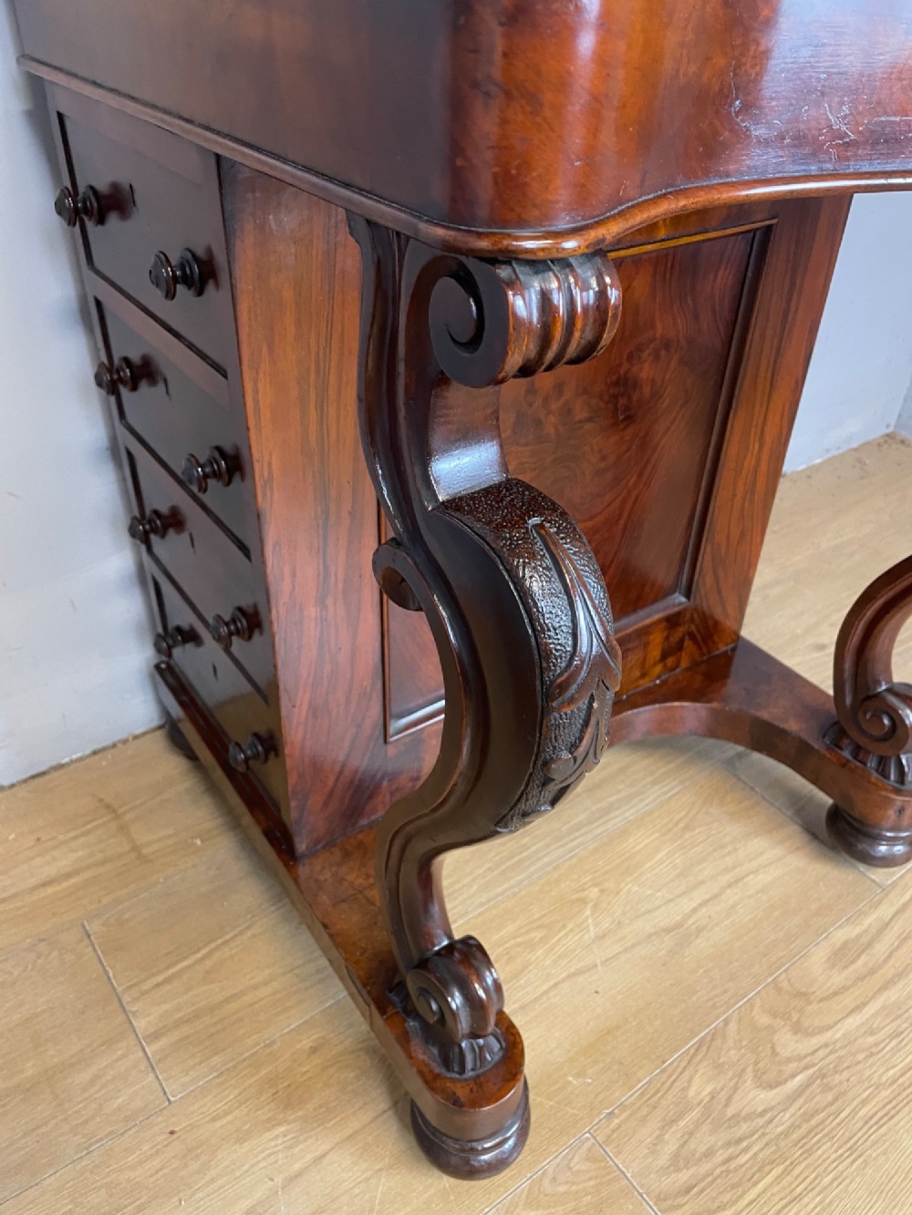 A late 19th-century walnut Davenport desk featuring a sloped leather writing top, carved cabriole front supports, and side drawers. View XI