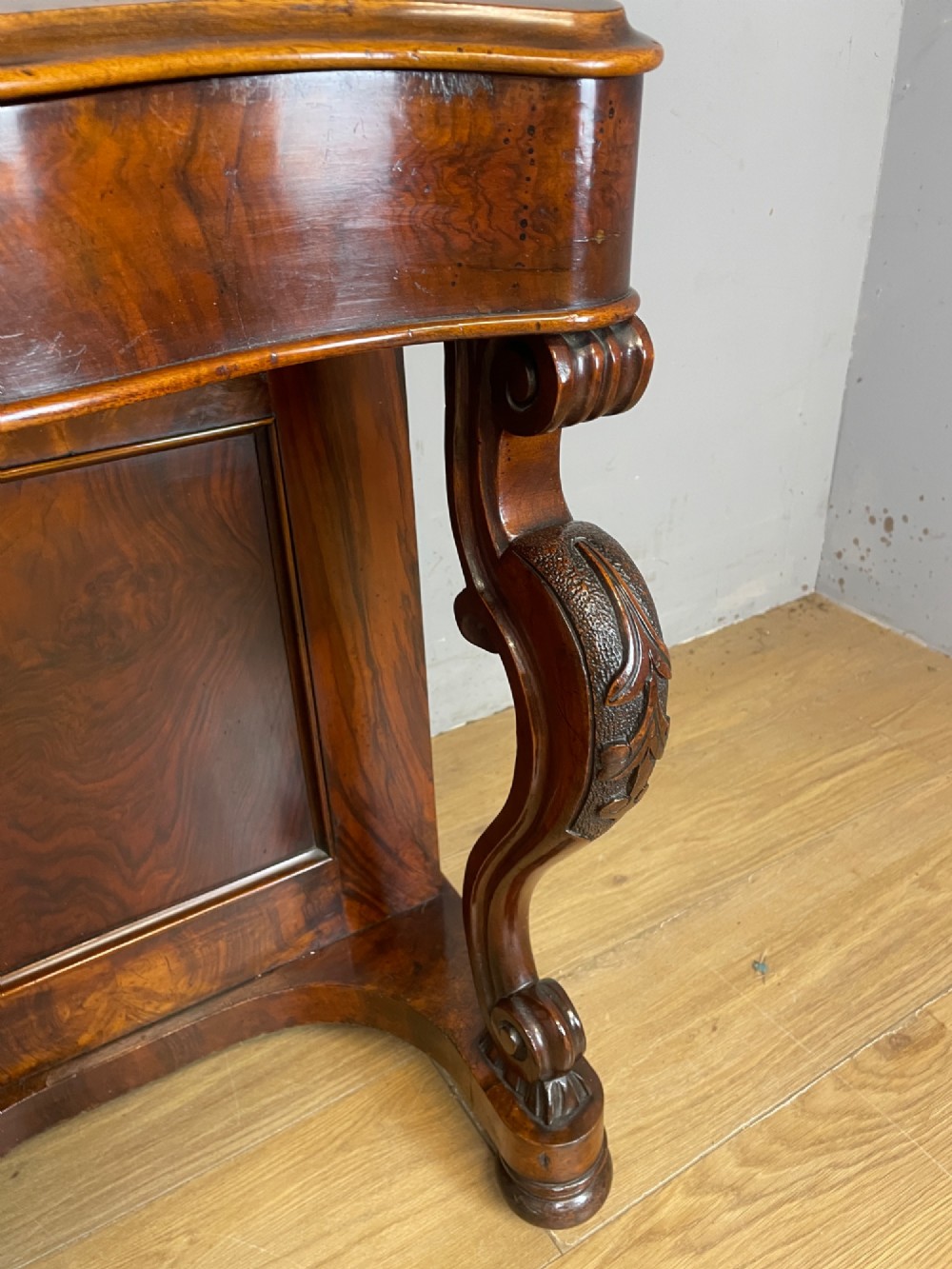 A late 19th-century walnut Davenport desk featuring a sloped leather writing top, carved cabriole front supports, and side drawers. View XII