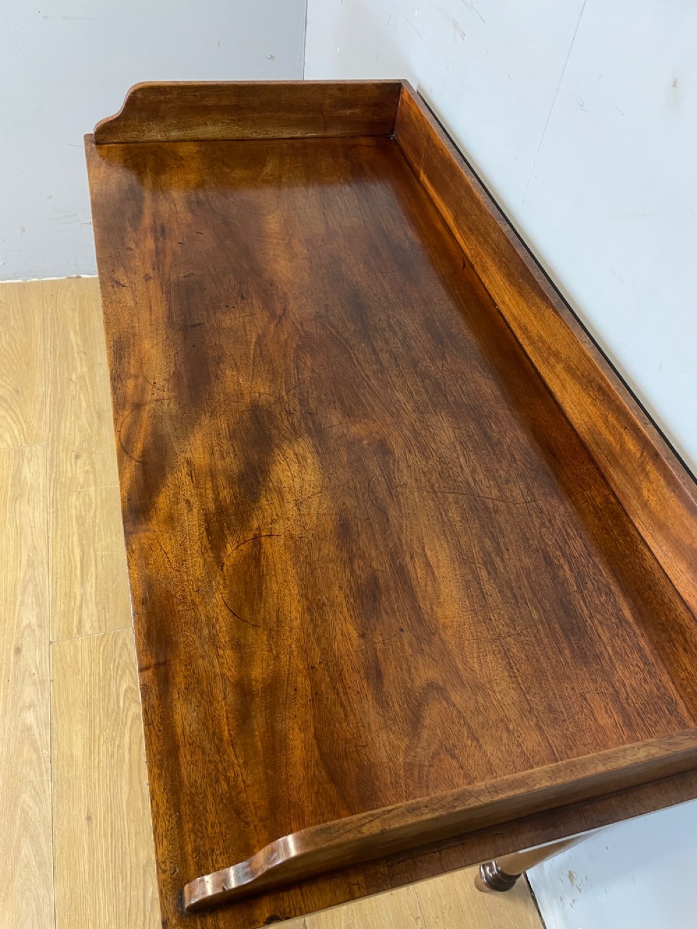 A nineteenth-century flame mahogany side table featuring a three-sided gallery top, two inline drawers with turned knobs, and four turned legs. View VI