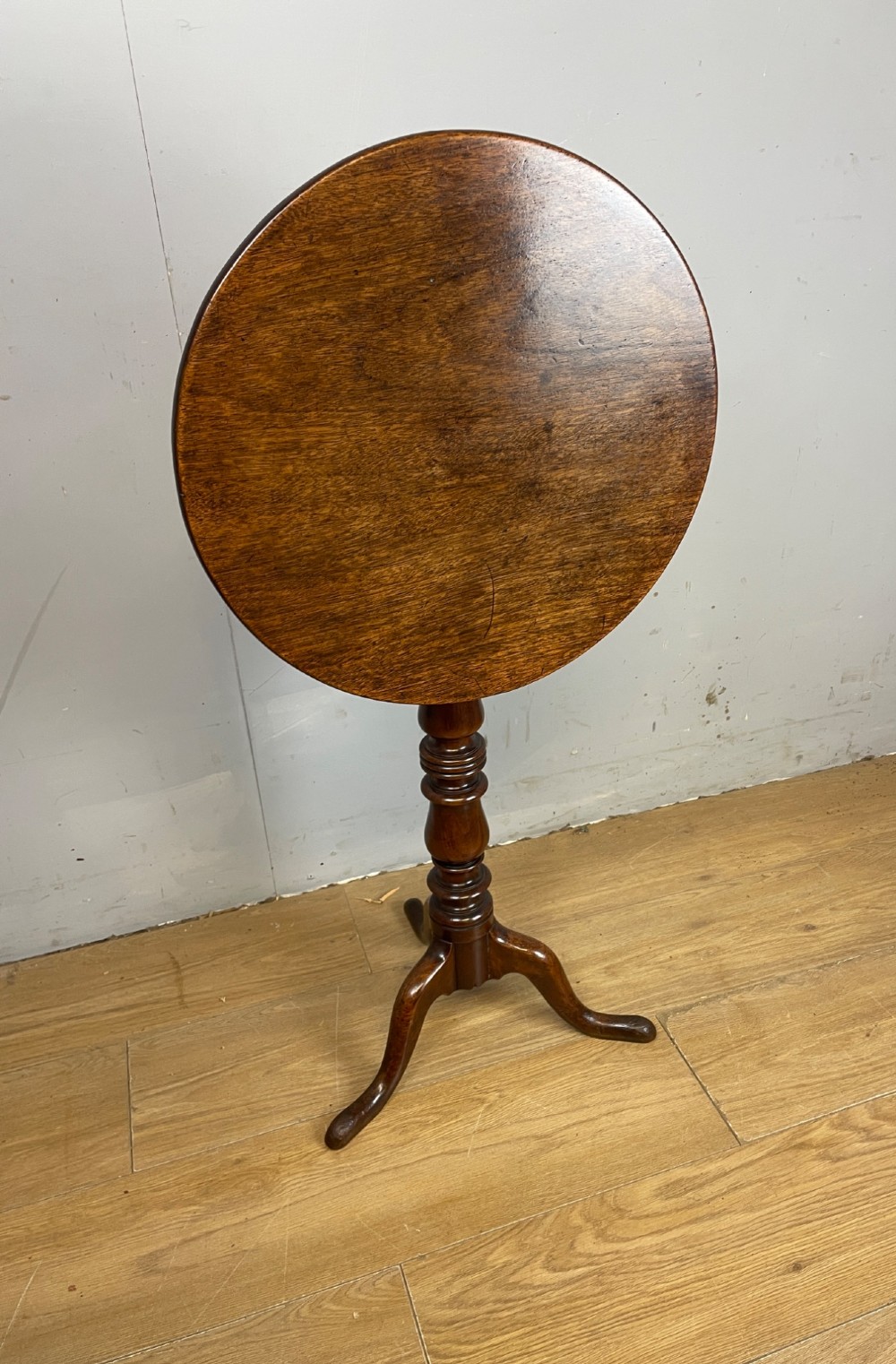 A Georgian mahogany wine table featuring a circular tilt top supported by a turned central pillar and three splayed legs. View VII