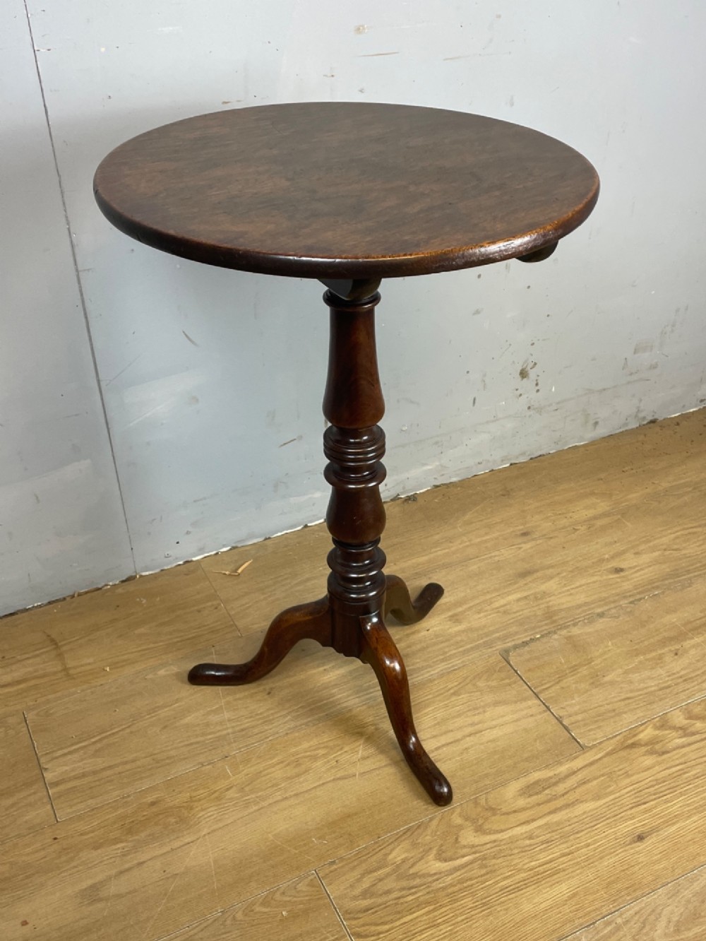 A Georgian mahogany wine table featuring a circular tilt top supported by a turned central pillar and three splayed legs. View XI