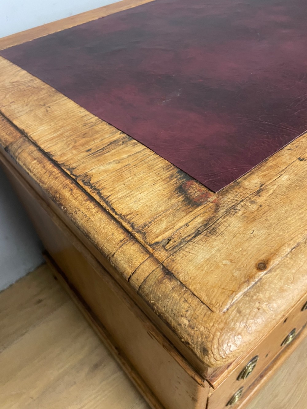 A Victorian three-part pine twin pedestal desk featuring a burgundy leather writing inset, multiple brass ring-pull drawers, and a plinth base. View XII