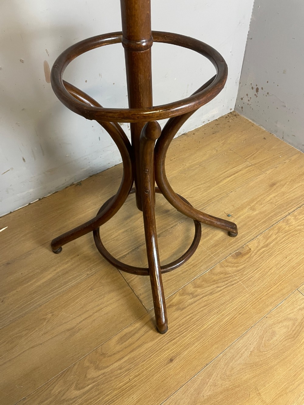 A tall dark brown bentwood freestanding coat and stick stand featuring curved upper hooks and a circular umbrella holder base. View IV