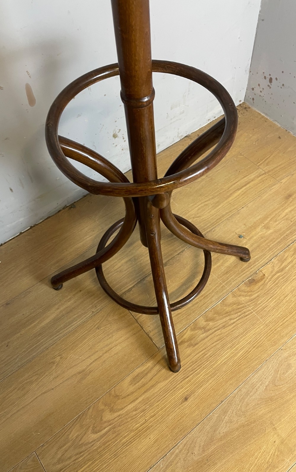A tall dark brown bentwood freestanding coat and stick stand featuring curved upper hooks and a circular umbrella holder base. View VI