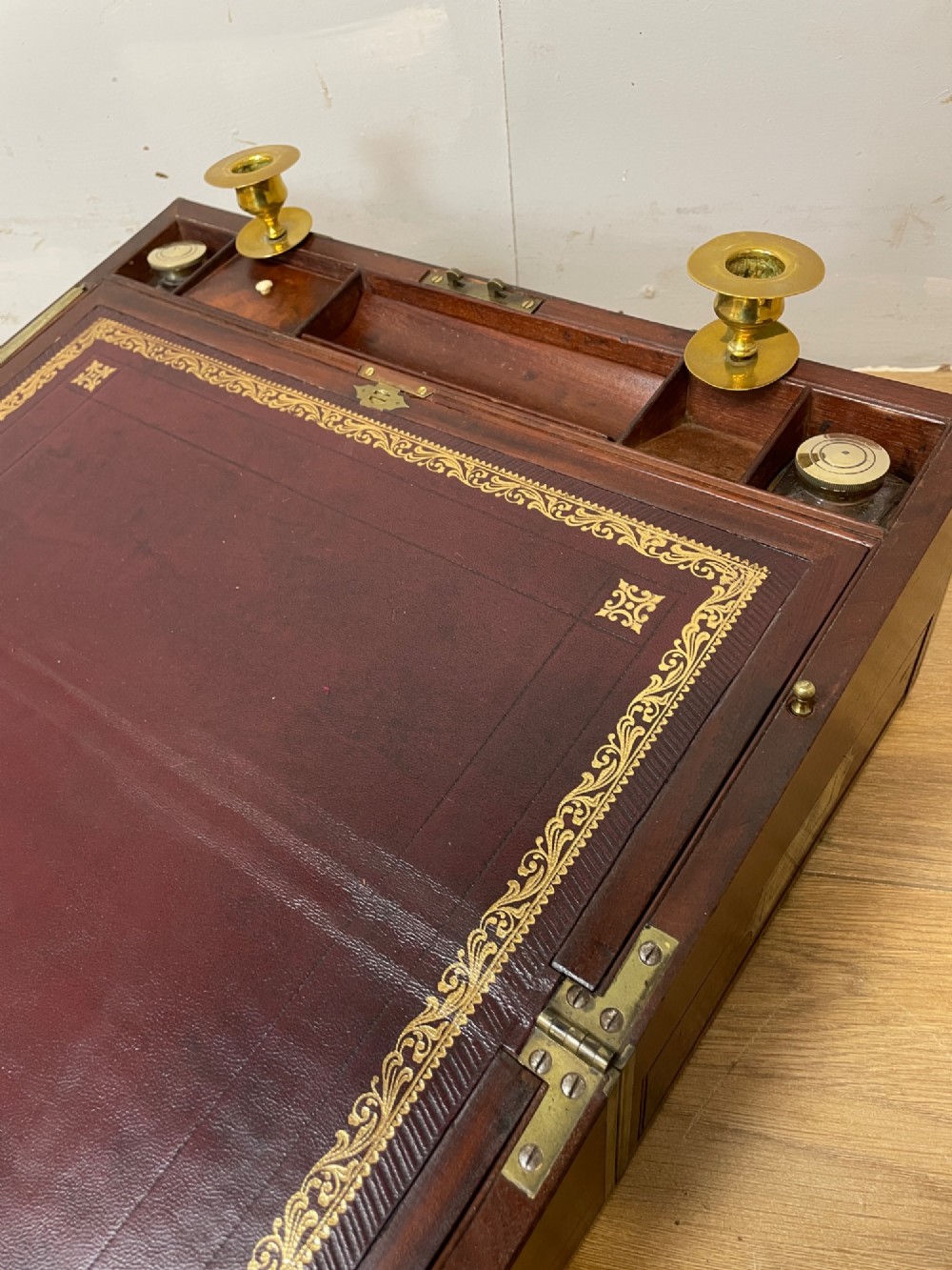 A 19th-century mahogany campaign writing slope featuring brass corner mounts, candle holders, and a gold-tooled burgundy leather writing surface. View IV