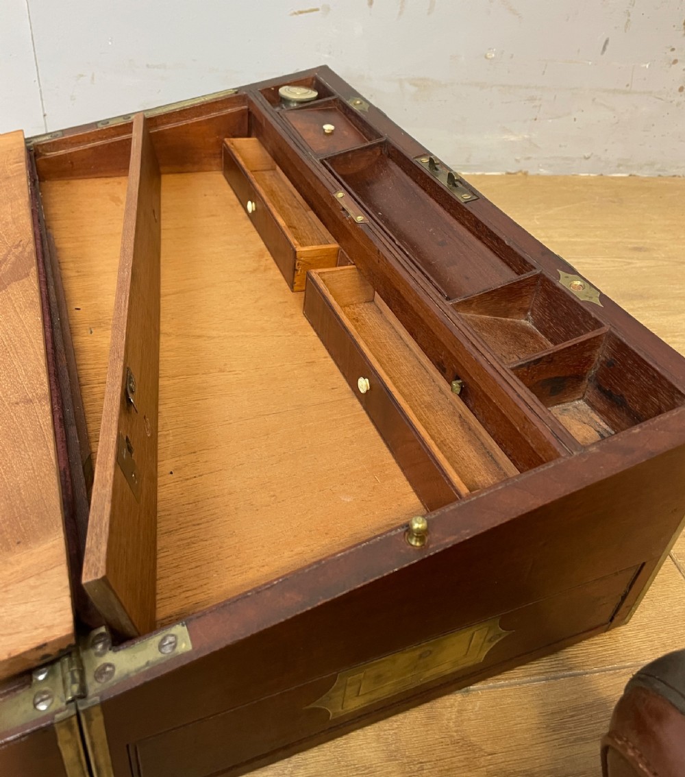 A 19th-century mahogany campaign writing slope featuring brass corner mounts, candle holders, and a gold-tooled burgundy leather writing surface. View VII