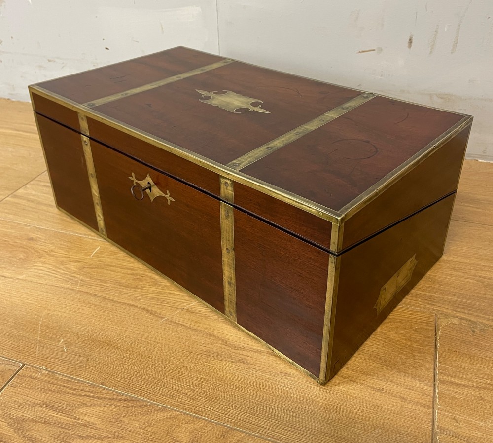 A 19th-century mahogany campaign writing slope featuring brass corner mounts, candle holders, and a gold-tooled burgundy leather writing surface. View XII