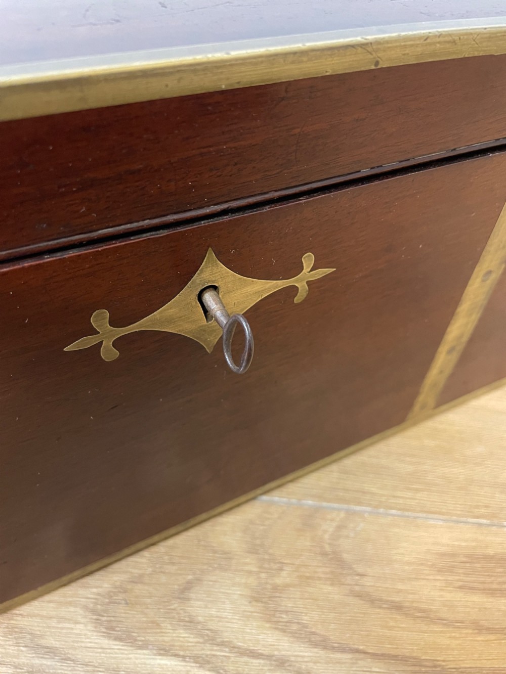A 19th-century mahogany campaign writing slope featuring brass corner mounts, candle holders, and a gold-tooled burgundy leather writing surface. View XIV