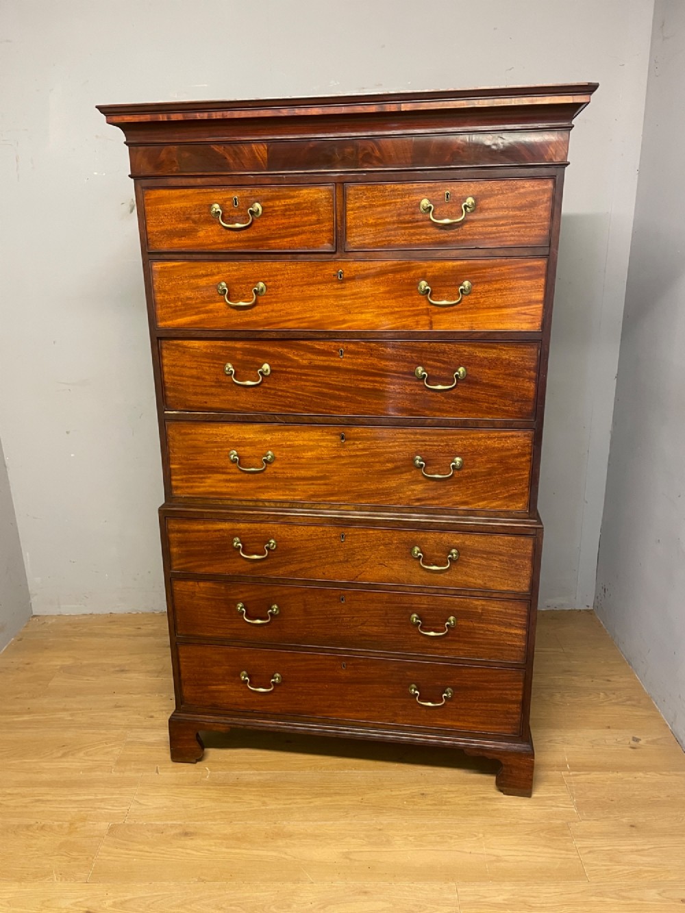A late 18th-century mahogany chest on chest featuring two short drawers over six long drawers with brass handles and bracket feet. View II
