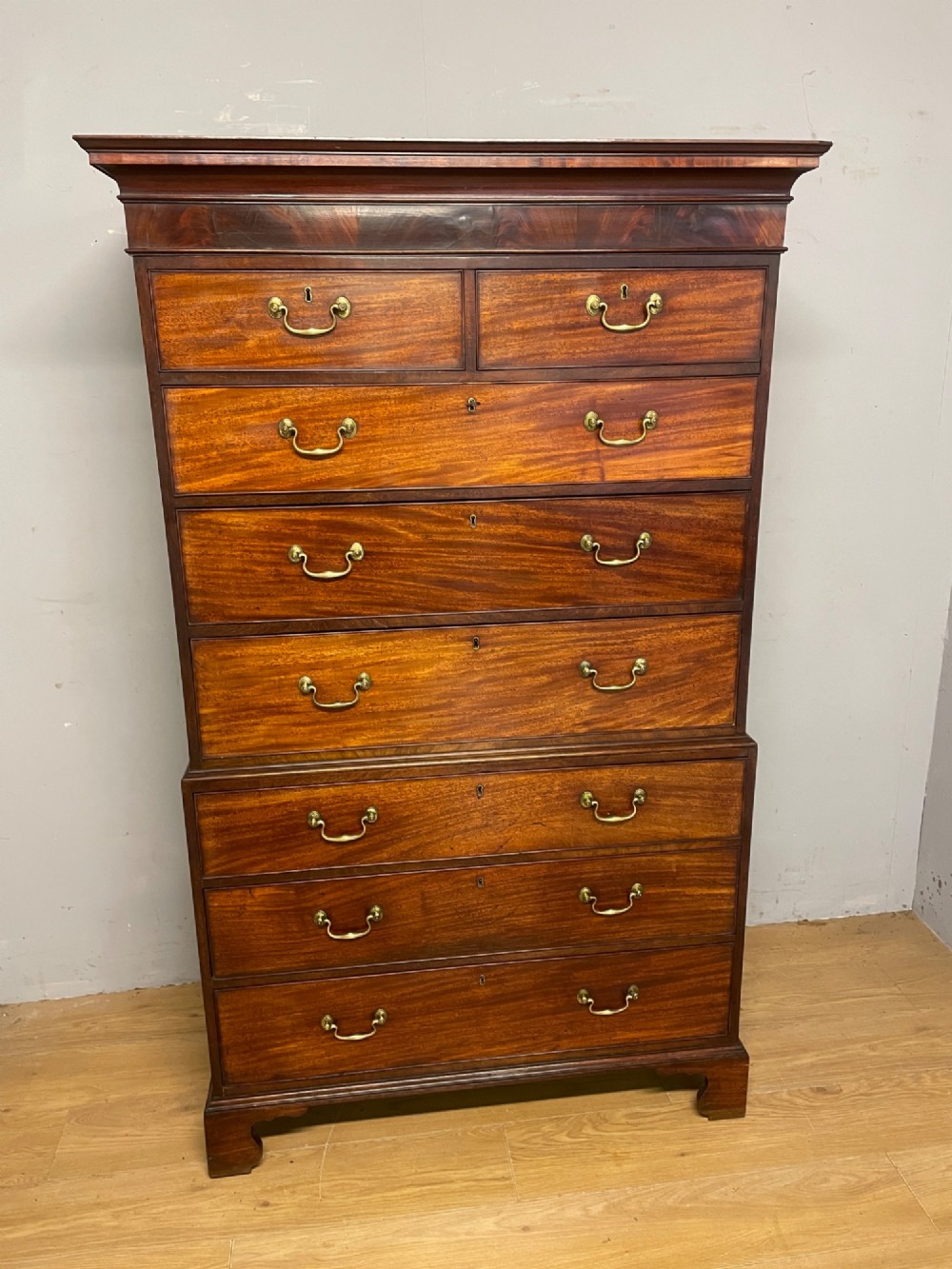 A late 18th-century mahogany chest on chest featuring two short drawers over six long drawers with brass handles and bracket feet. View IV