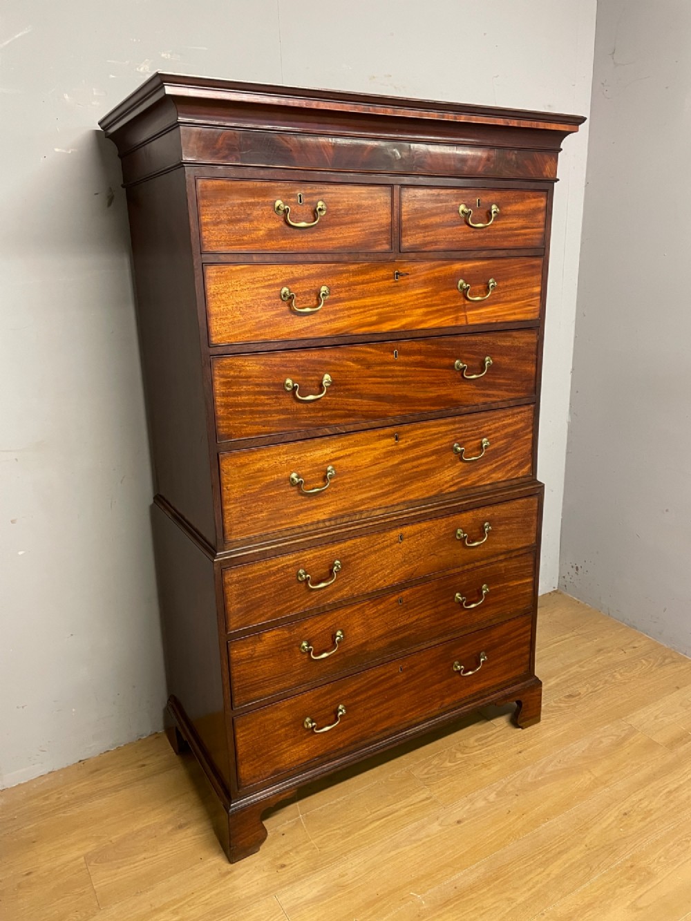A late 18th-century mahogany chest on chest featuring two short drawers over six long drawers with brass handles and bracket feet. View V