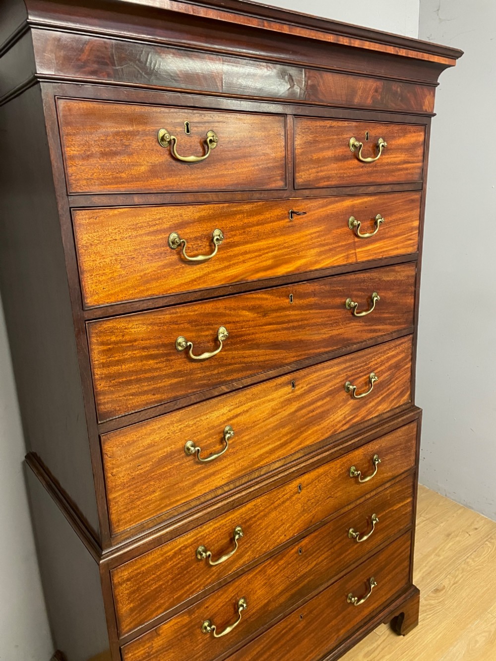 A late 18th-century mahogany chest on chest featuring two short drawers over six long drawers with brass handles and bracket feet. View VI