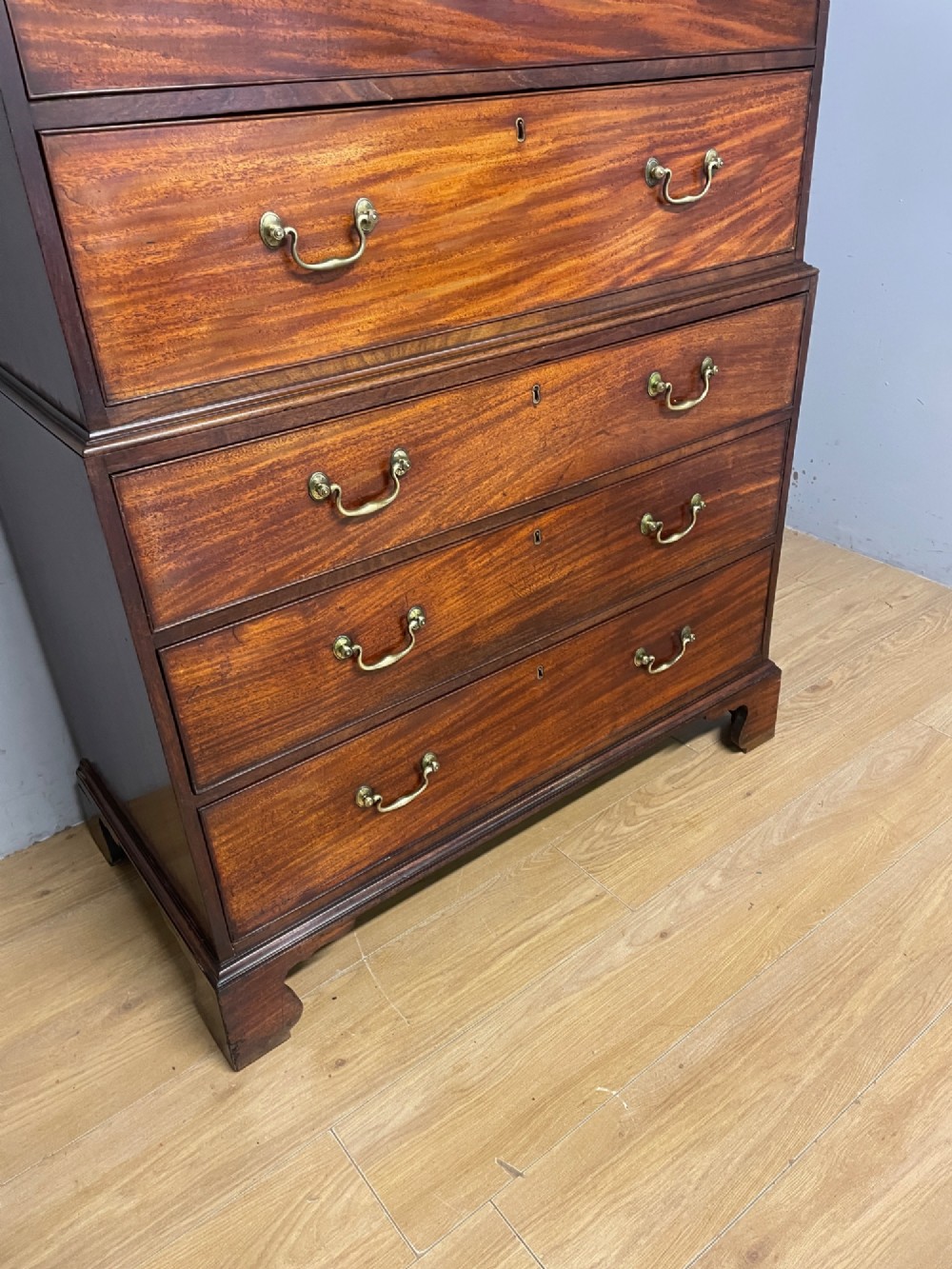 A late 18th-century mahogany chest on chest featuring two short drawers over six long drawers with brass handles and bracket feet. View VII