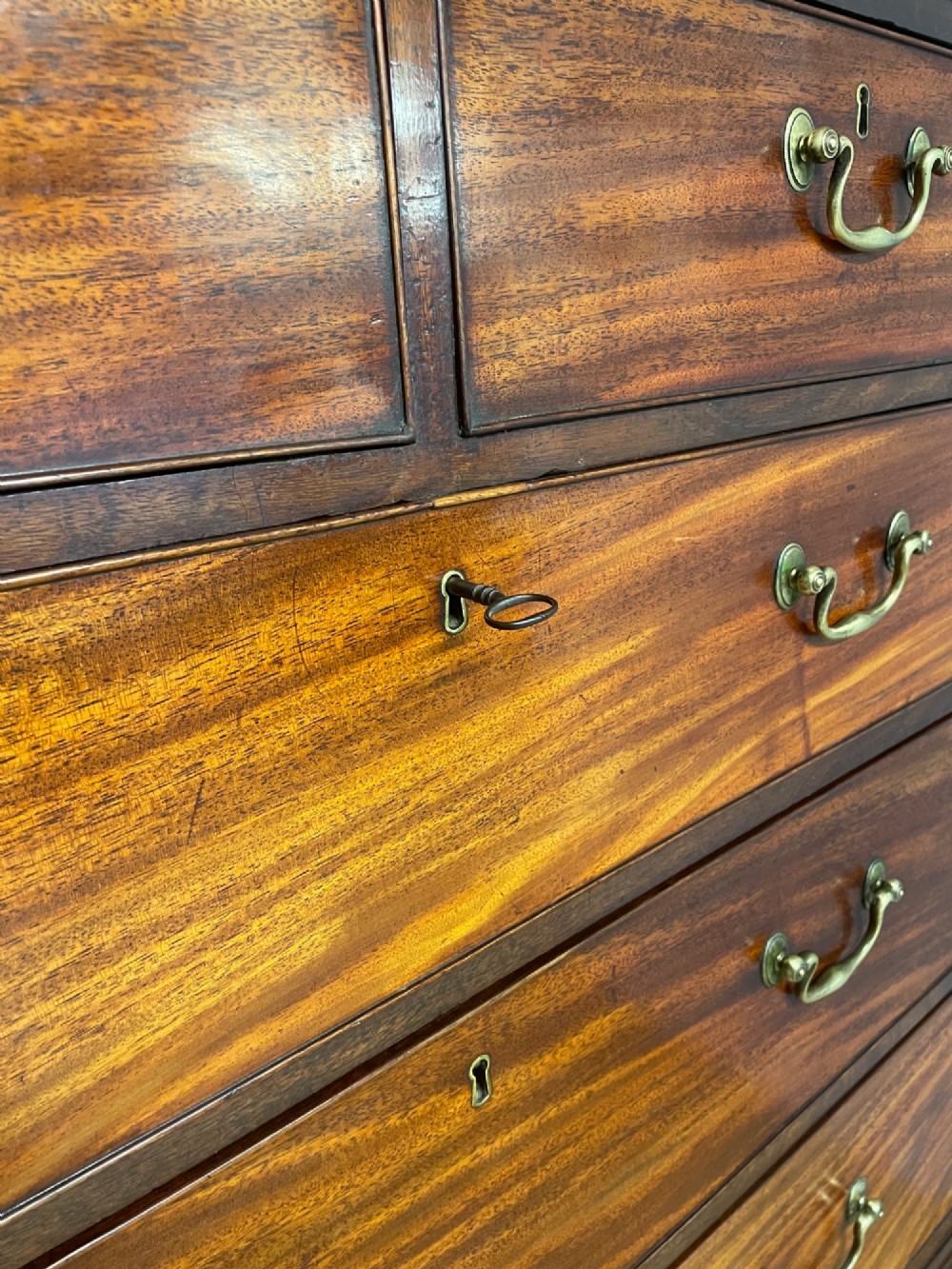 A late 18th-century mahogany chest on chest featuring two short drawers over six long drawers with brass handles and bracket feet. View VIII