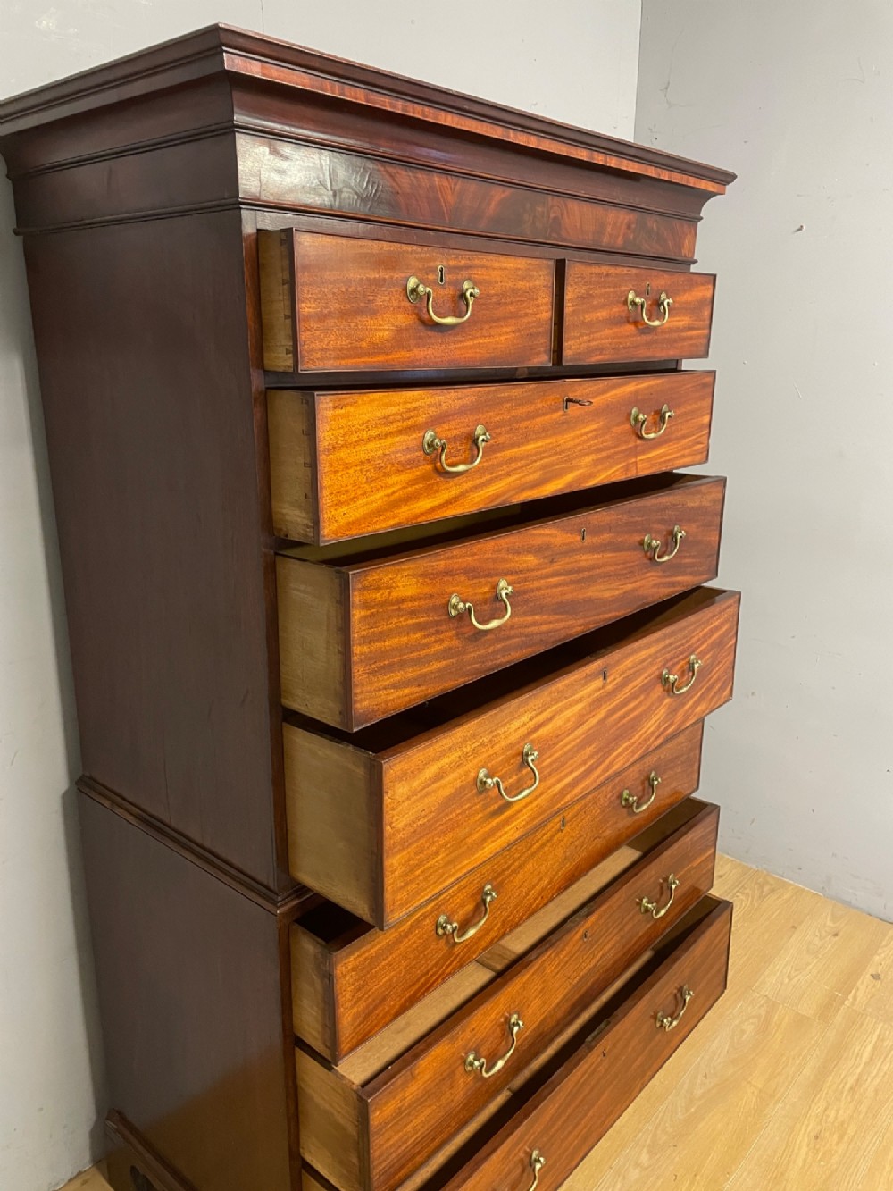 A late 18th-century mahogany chest on chest featuring two short drawers over six long drawers with brass handles and bracket feet. View IX