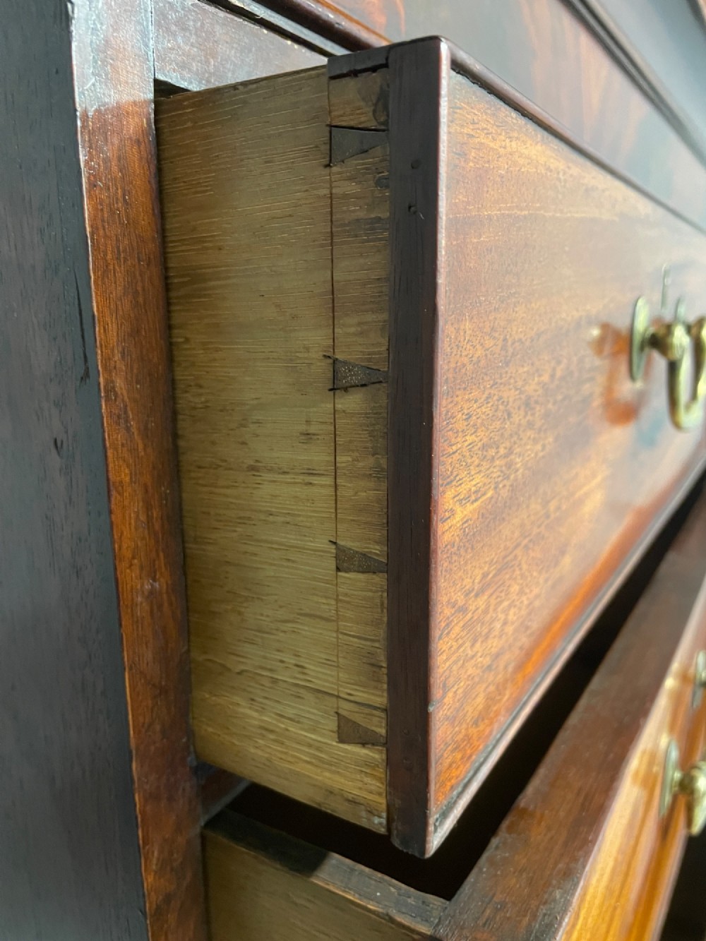 A late 18th-century mahogany chest on chest featuring two short drawers over six long drawers with brass handles and bracket feet. View XI