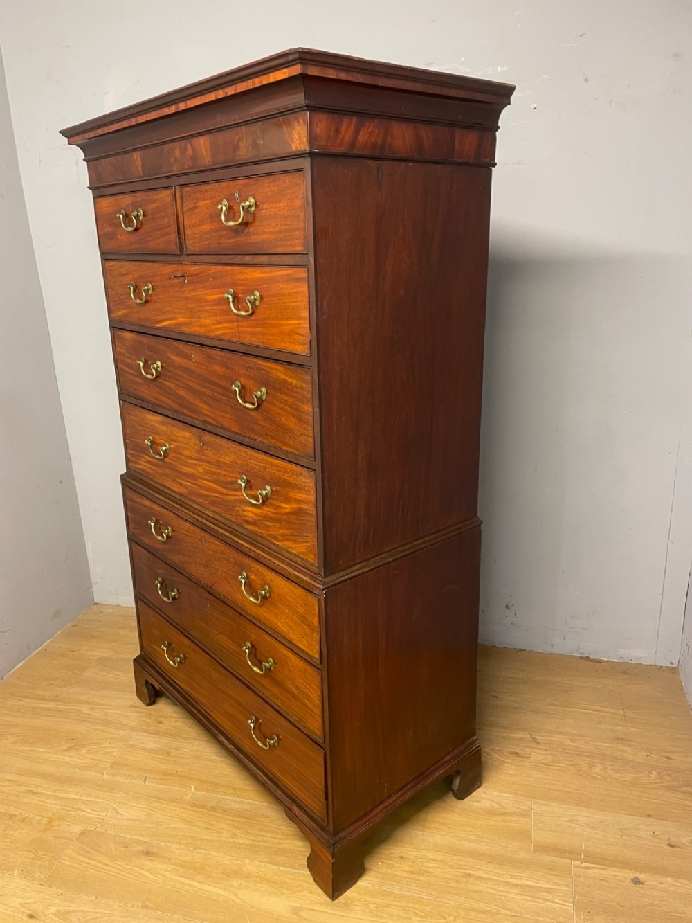 A late 18th-century mahogany chest on chest featuring two short drawers over six long drawers with brass handles and bracket feet. View XIII