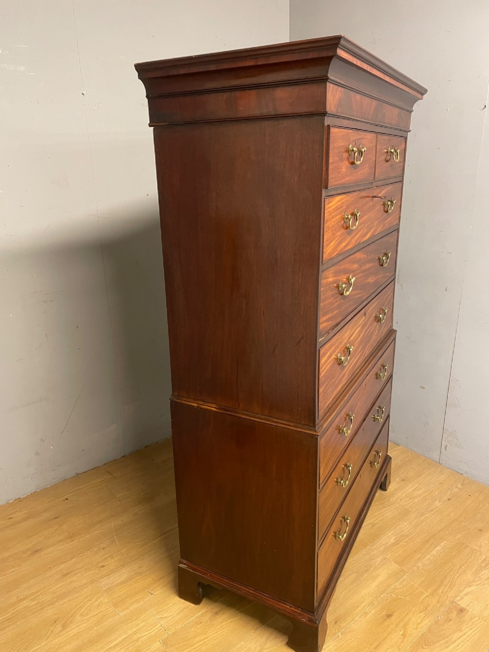 A late 18th-century mahogany chest on chest featuring two short drawers over six long drawers with brass handles and bracket feet. View XIV