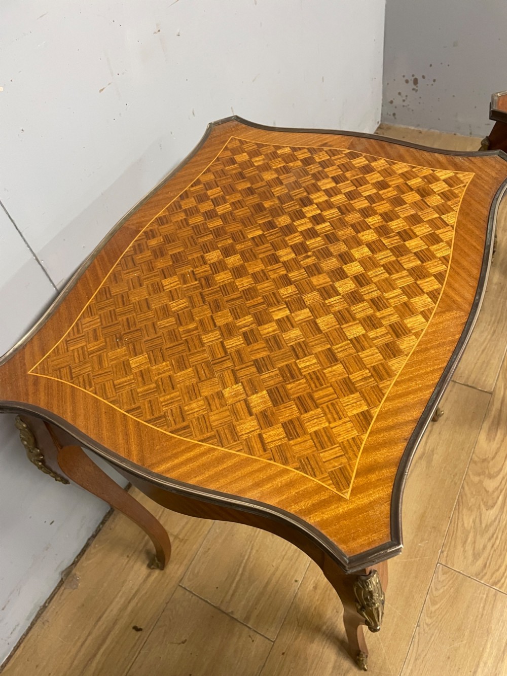 A set of three graduated French kingwood nesting tables featuring parquetry inlaid tops, cabriole legs, and gilded ormolu mounts. View VIII