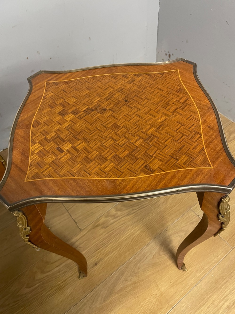 A set of three graduated French kingwood nesting tables featuring parquetry inlaid tops, cabriole legs, and gilded ormolu mounts. View IX