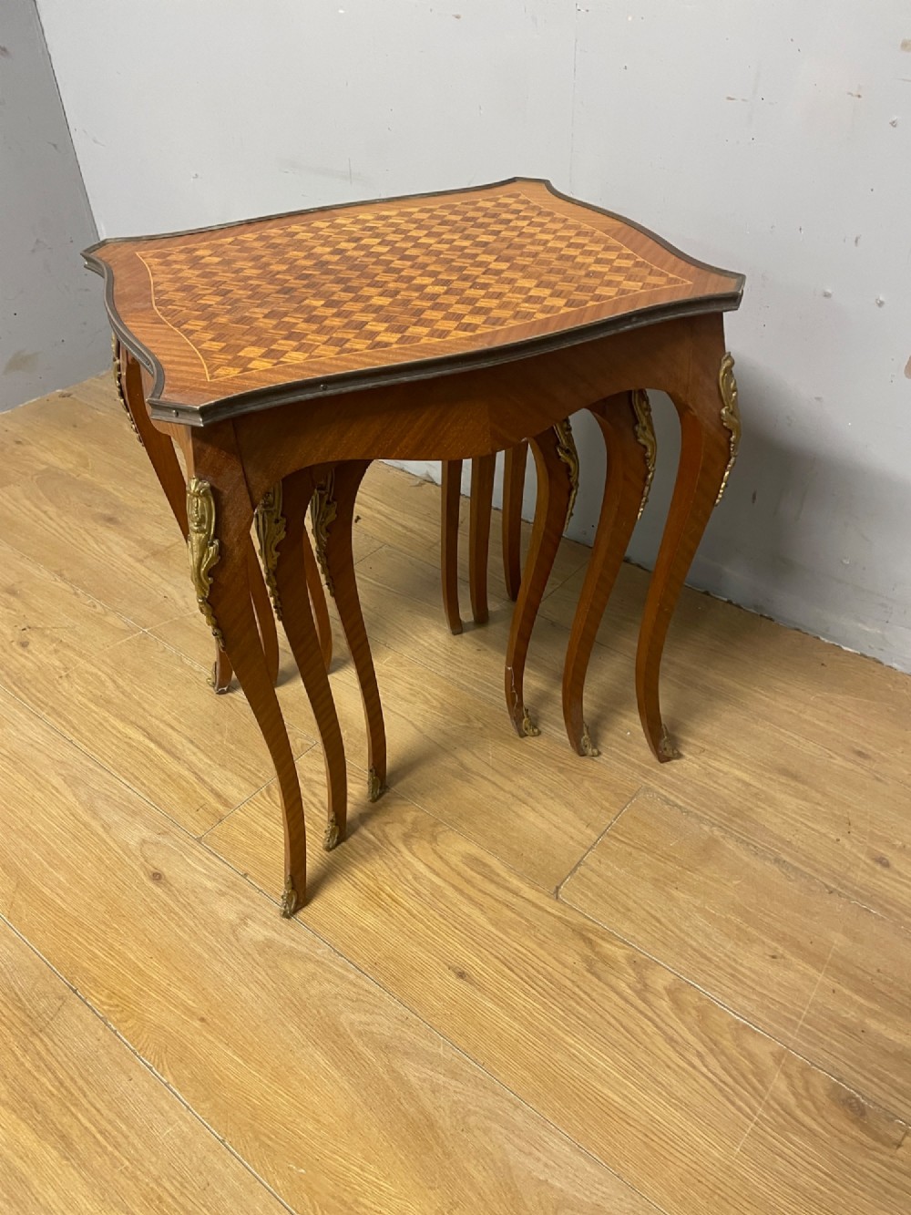 A set of three graduated French kingwood nesting tables featuring parquetry inlaid tops, cabriole legs, and gilded ormolu mounts. View XI