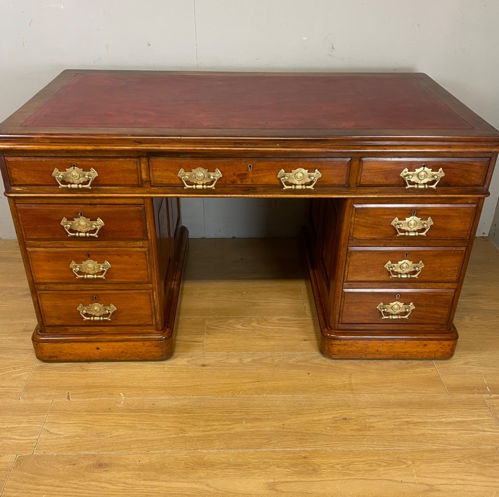 A 19th-century walnut twin pedestal desk featuring a red leather writing insert and brass drop handles. View II