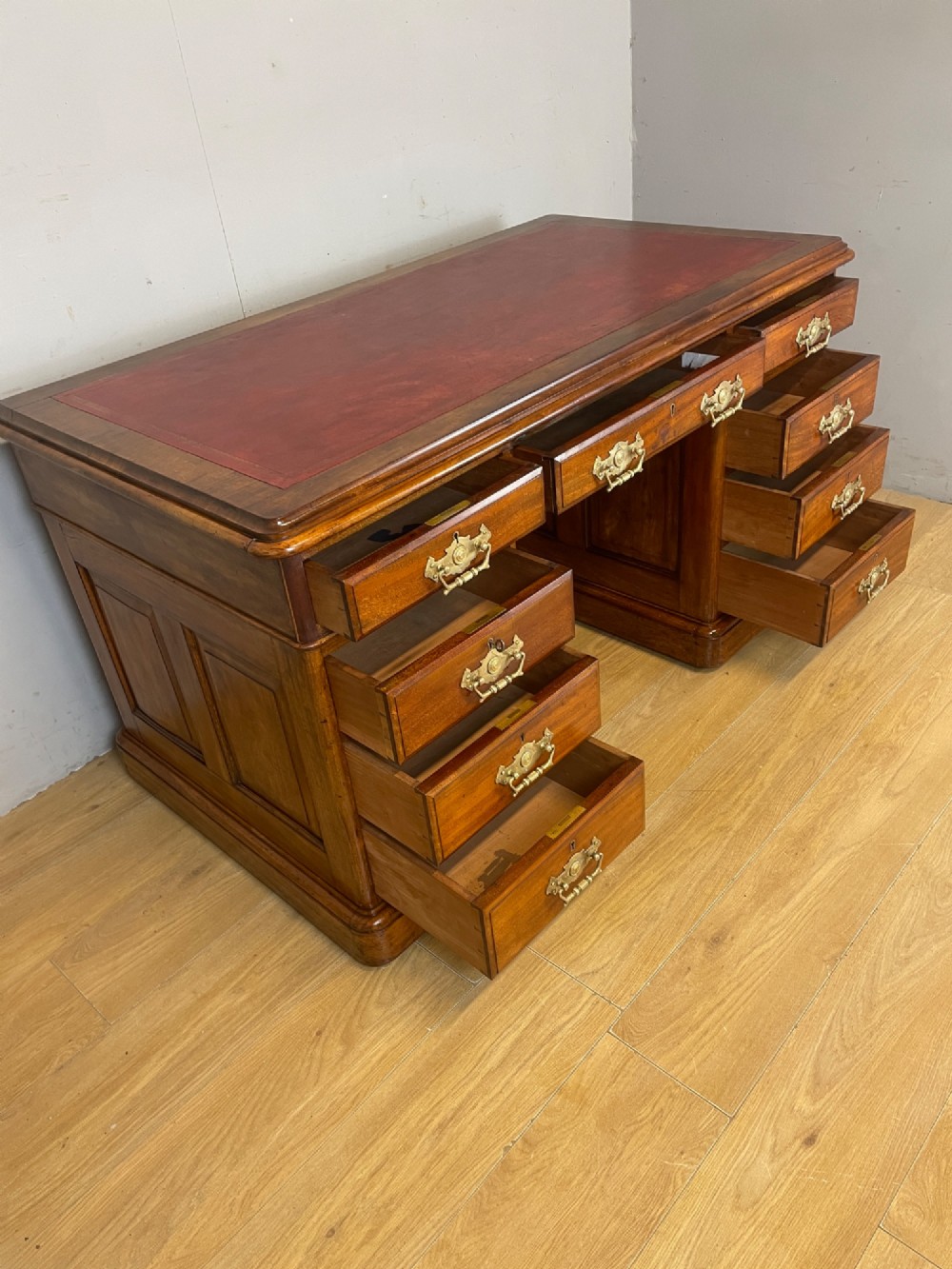 A 19th-century walnut twin pedestal desk featuring a red leather writing insert and brass drop handles. View IX