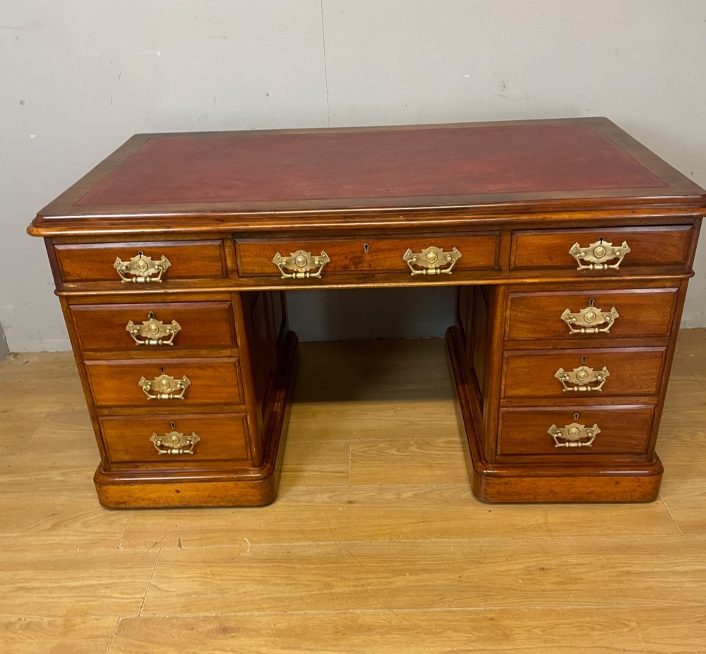 A 19th-century walnut twin pedestal desk featuring a red leather writing insert and brass drop handles. View XII