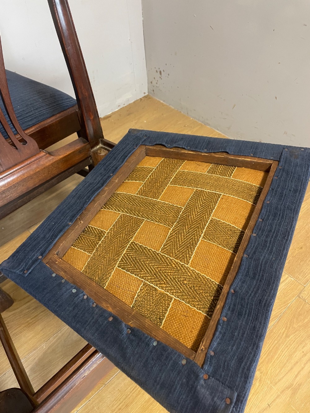 A set of four antique mahogany Chippendale style dining chairs with decorative pierced back splats and dark upholstered seats arranged side by side. View IX