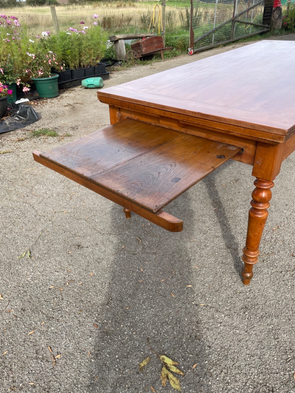 A 19th-century French cherrywood extending dining table featuring turned legs and a polished rectangular top. View V