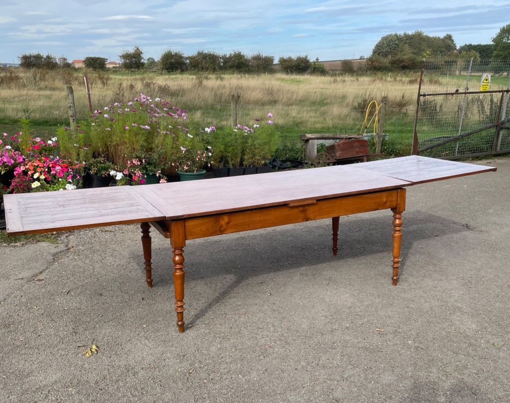 A 19th-century French cherrywood extending dining table featuring turned legs and a polished rectangular top. View VI