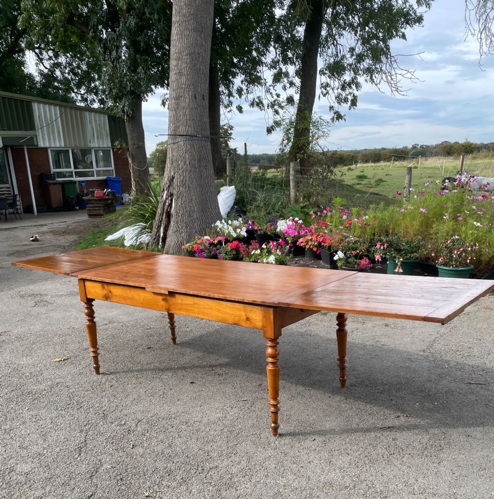 A 19th-century French cherrywood extending dining table featuring turned legs and a polished rectangular top. View X