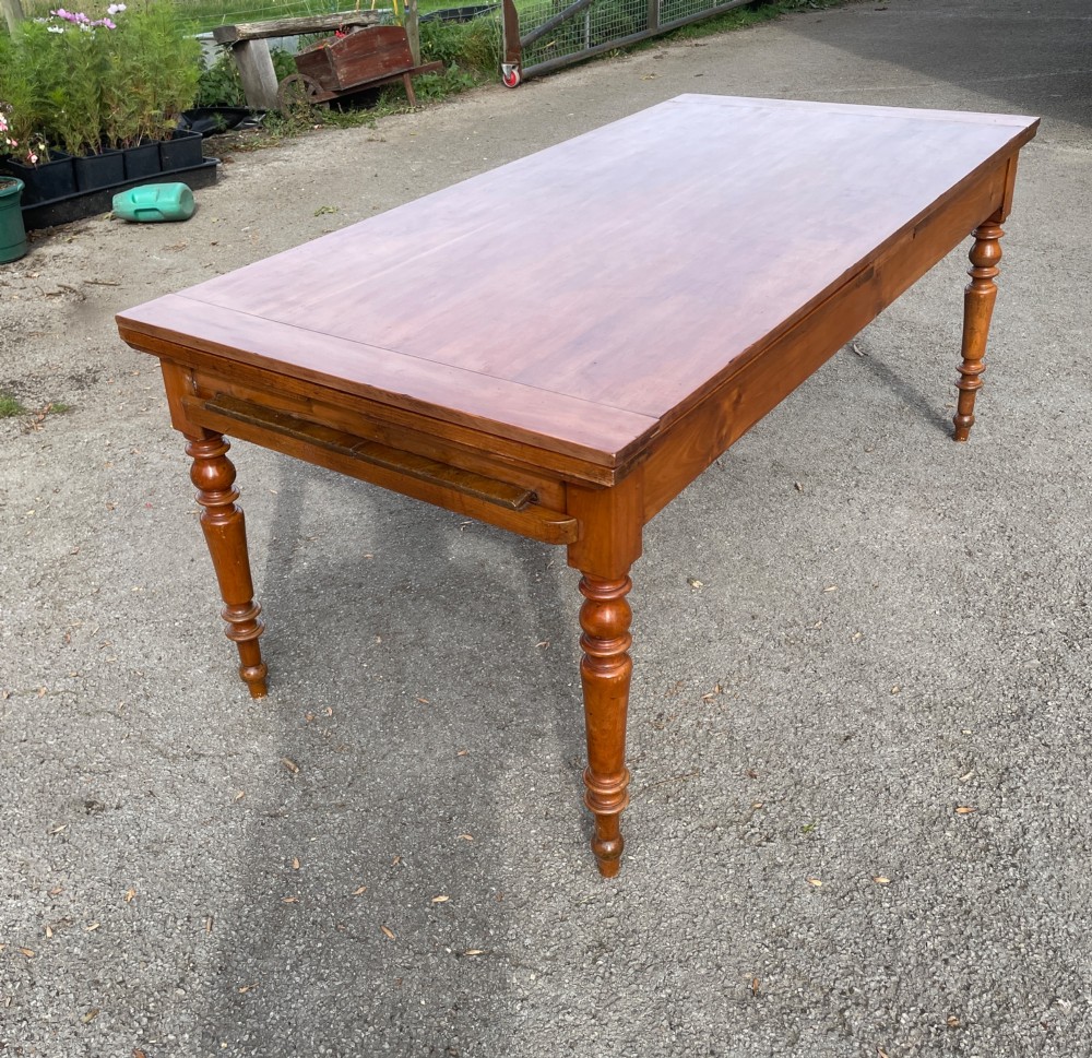 A 19th-century French cherrywood extending dining table featuring turned legs and a polished rectangular top. View XI