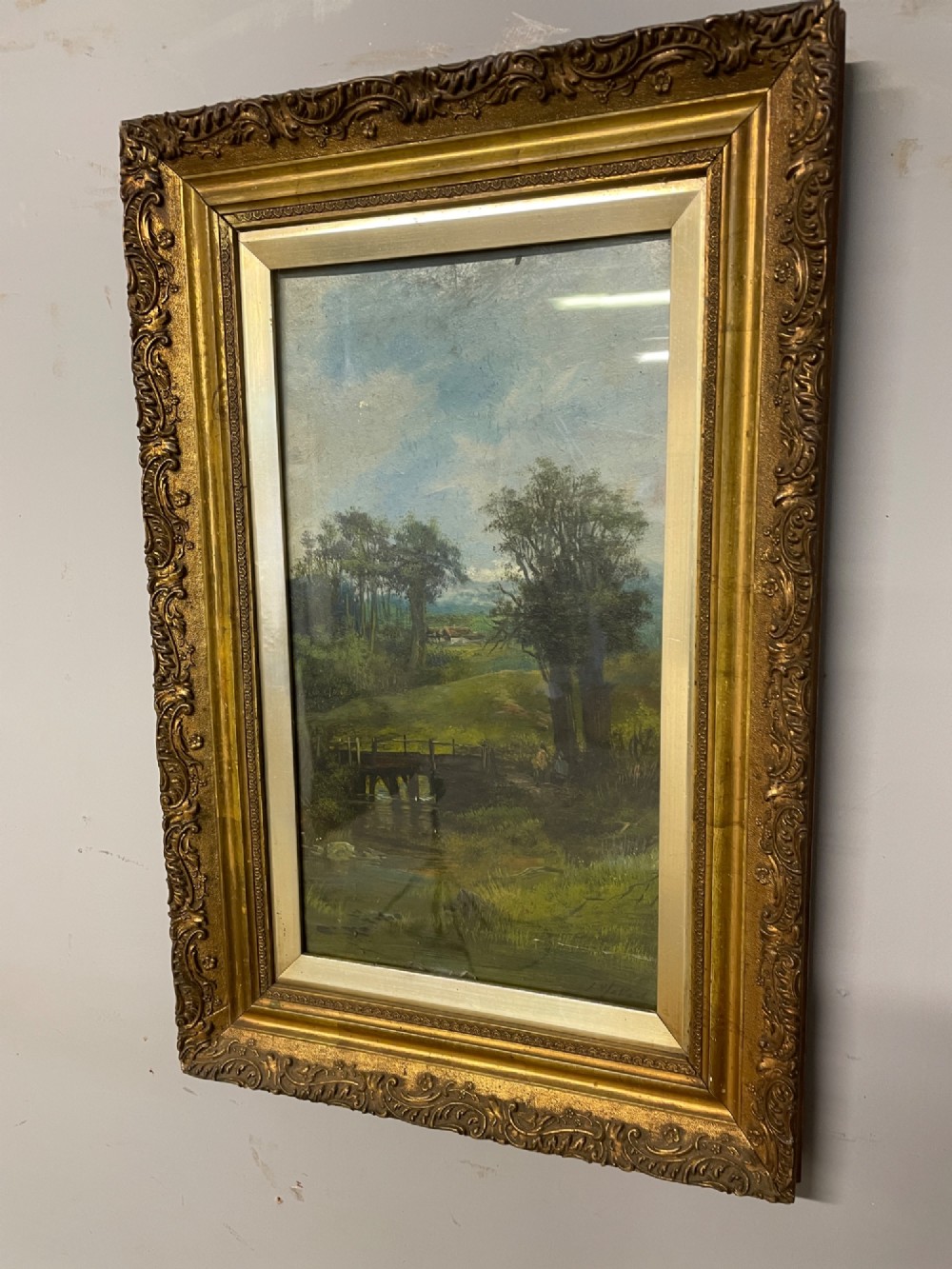 A pair of vertical late 19th-century oil paintings depicting green river and woodland landscapes in ornate gilded frames. View II