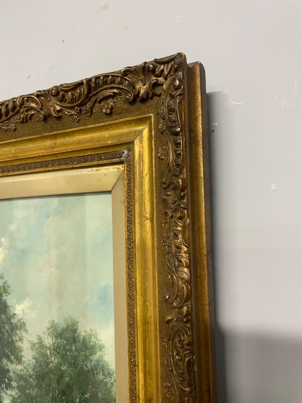 A pair of vertical late 19th-century oil paintings depicting green river and woodland landscapes in ornate gilded frames. View IX