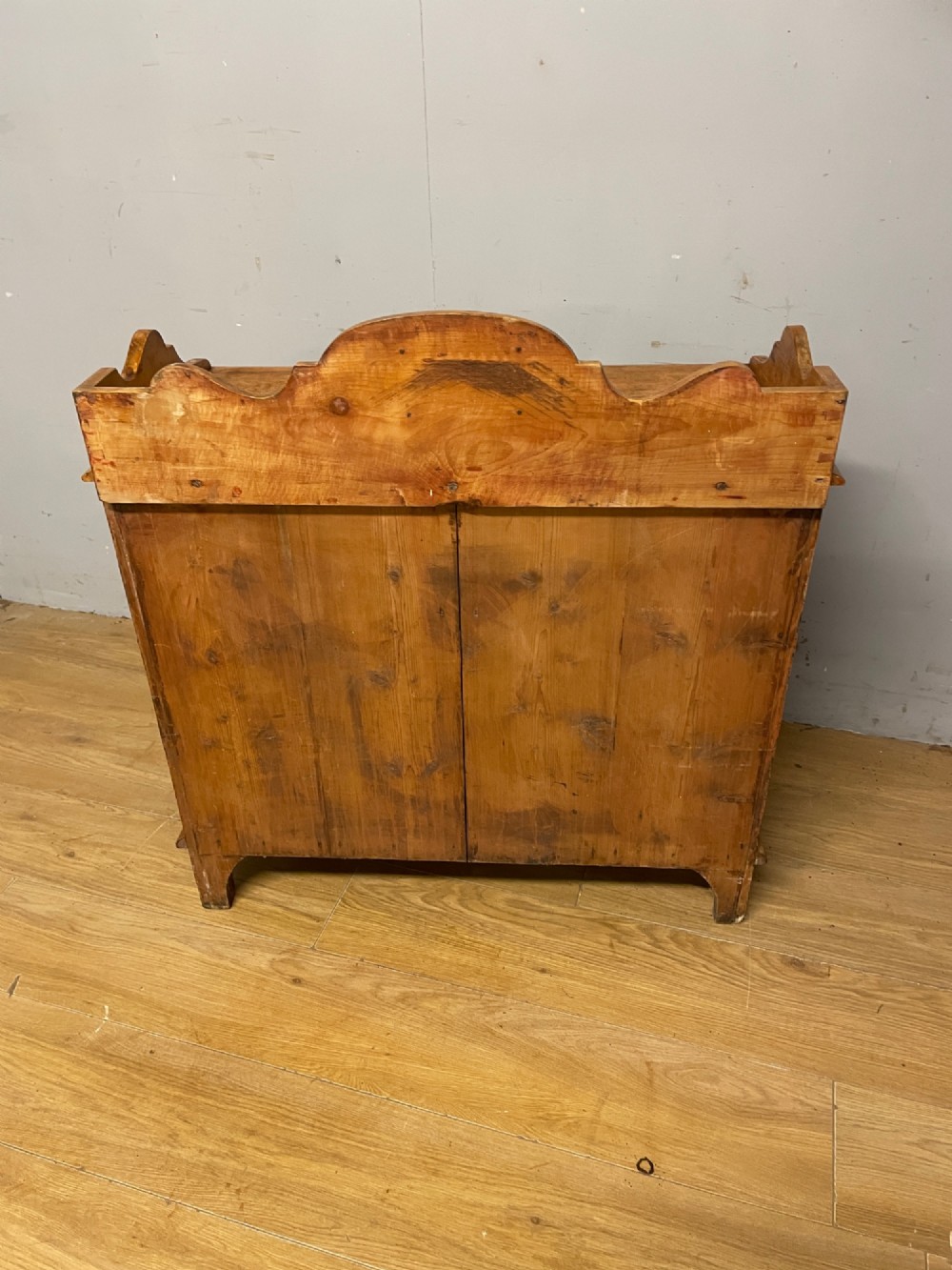 A nineteenth-century warm pine chest of drawers featuring a shaped gallery back, two short over two long drawers, and brass handles. View VIII