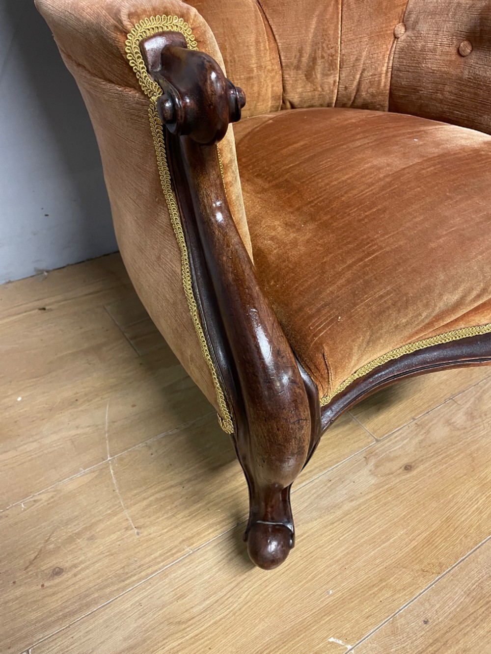 Victorian mahogany tub armchair upholstered in button-tufted amber velvet with curved front legs on brass castors. View IV