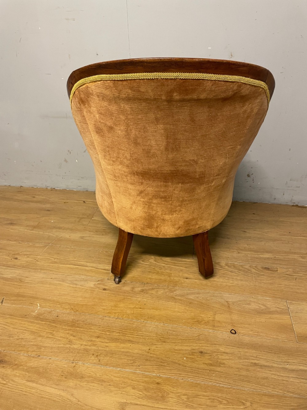 Victorian mahogany tub armchair upholstered in button-tufted amber velvet with curved front legs on brass castors. View VIII