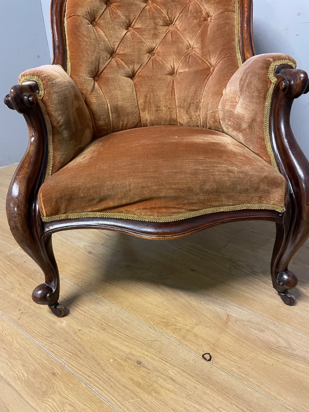 Victorian mahogany tub armchair upholstered in button-tufted amber velvet with curved front legs on brass castors. View XI